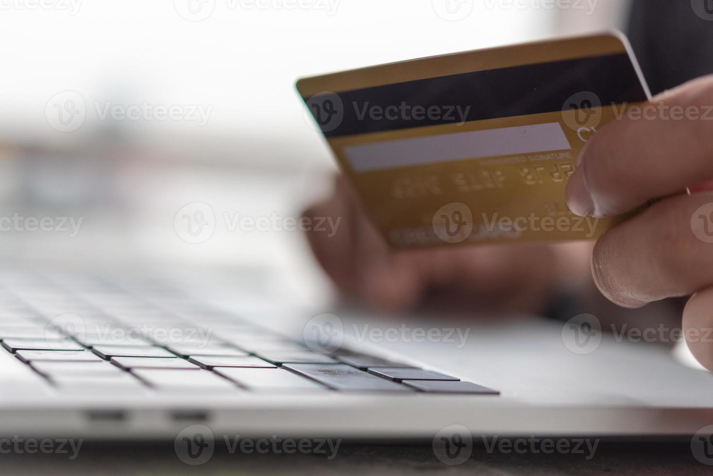 homme d'affaires utilisant une carte de crédit et un ordinateur portable pour se connecter à la banque Internet. photo