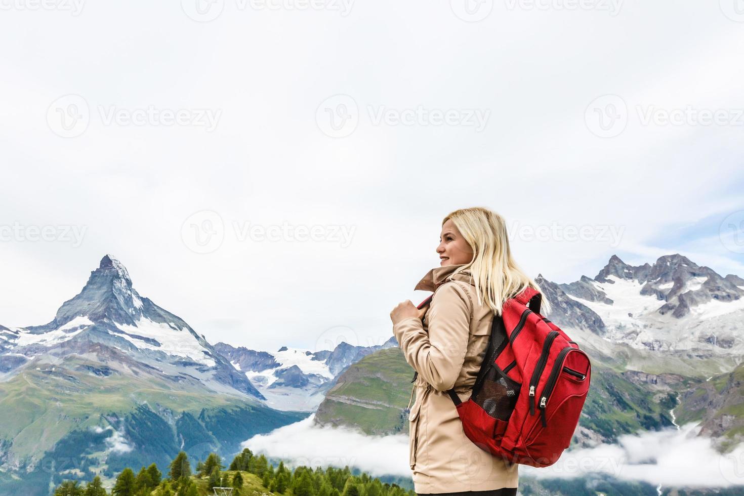 femme avec sac à dos de randonnée dans le désert de montagne enneigée. randonnée hipster photo