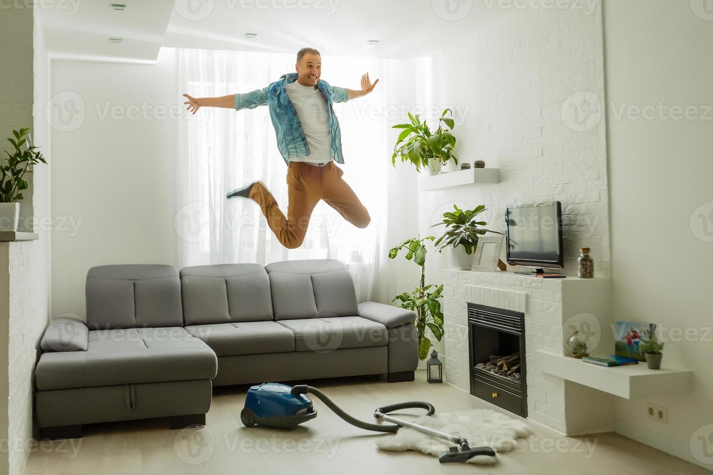 pandémie de coronavirus. un homme avec un aspirateur dans son appartement. bureau à domicile. quarantaine. travail à distance. un homme en chemise et caleçon tient. photo