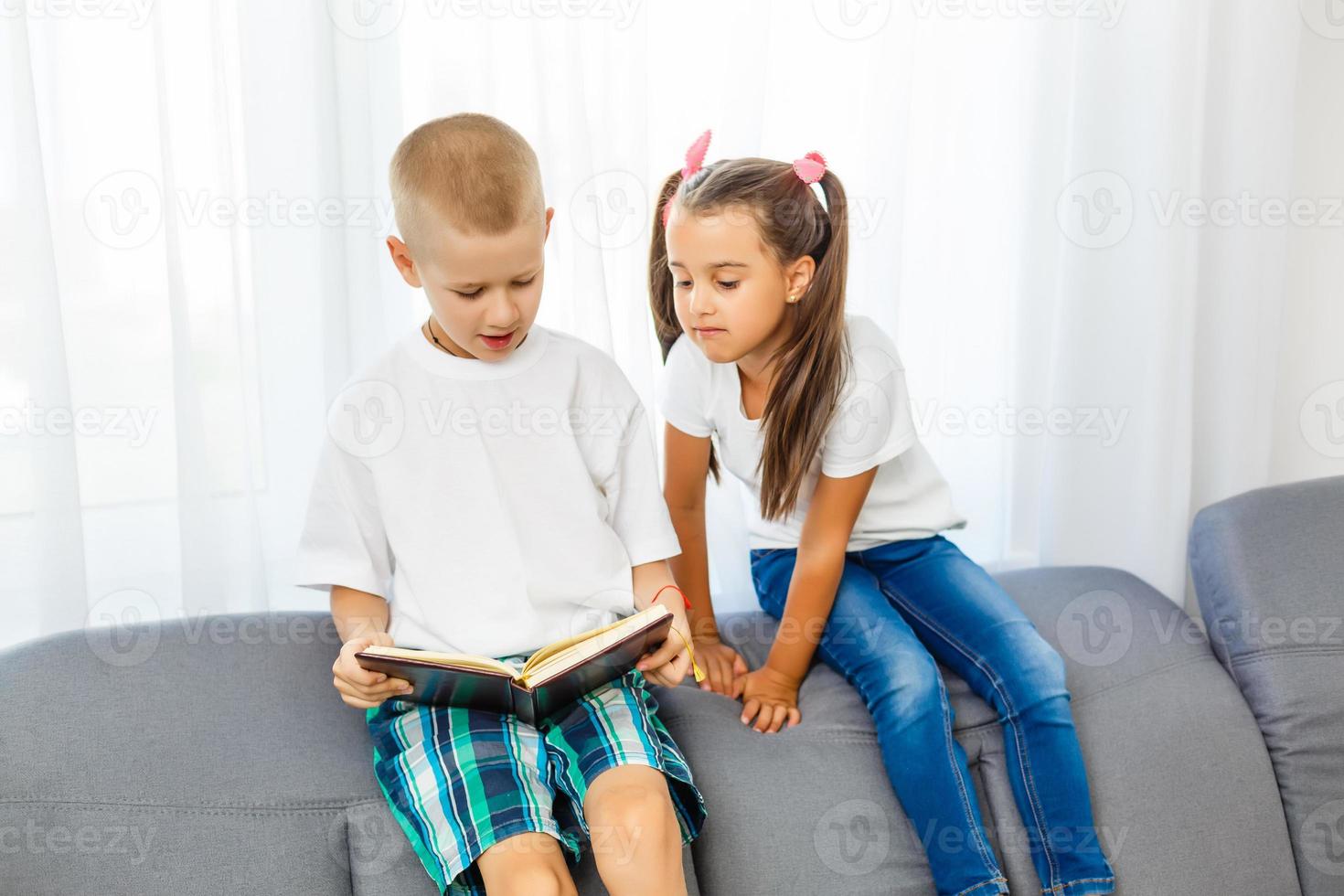 les enfants lisent un livre à la maison photo