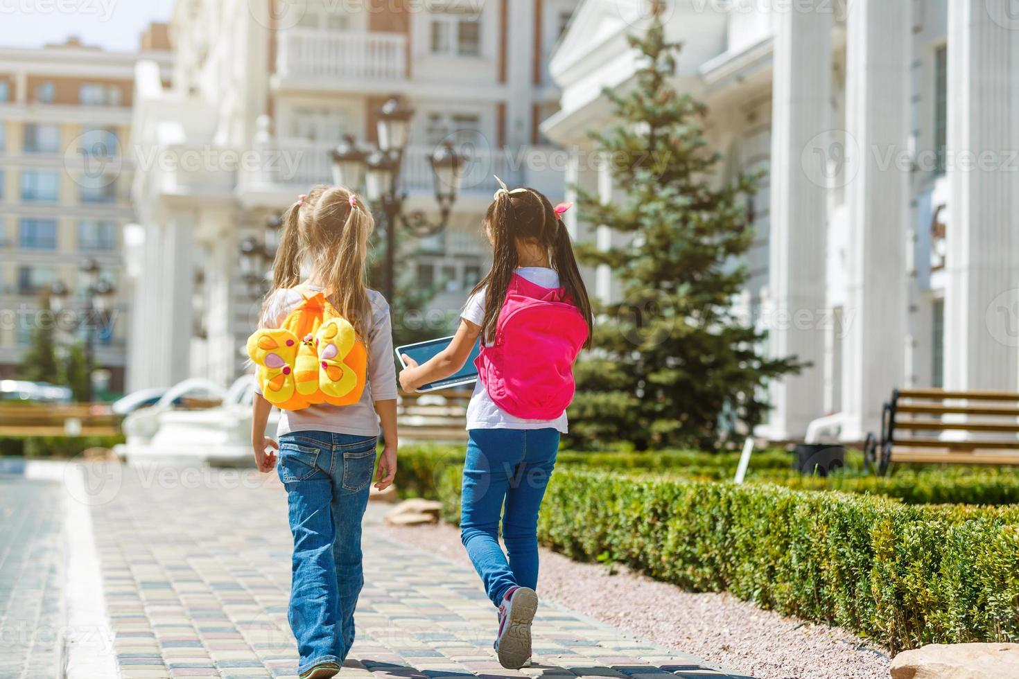 deux écolières vont à l'école. le concept d'école, d'étude, d'éducation, d'amitié, d'enfance. photo