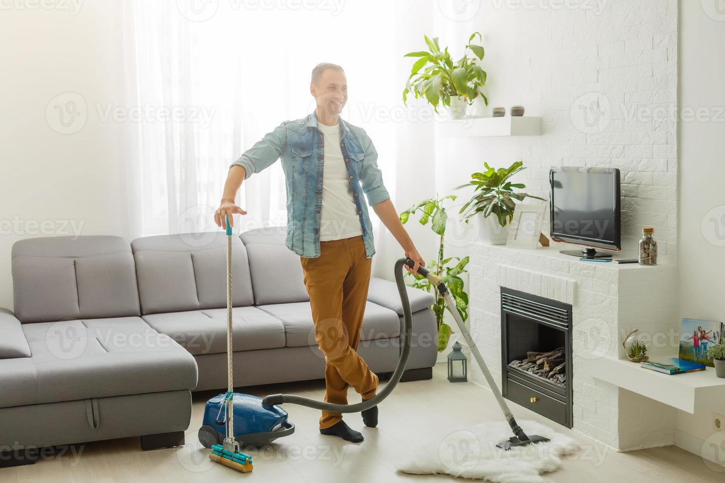 pandémie de coronavirus. un homme avec un aspirateur dans son appartement. bureau à domicile. quarantaine. travail à distance. un homme en chemise et caleçon tient. photo