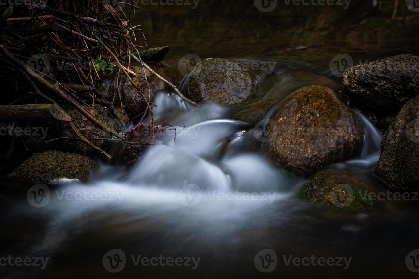 un petit ruisseau forestier avec des falaises de grès et des pierres photo