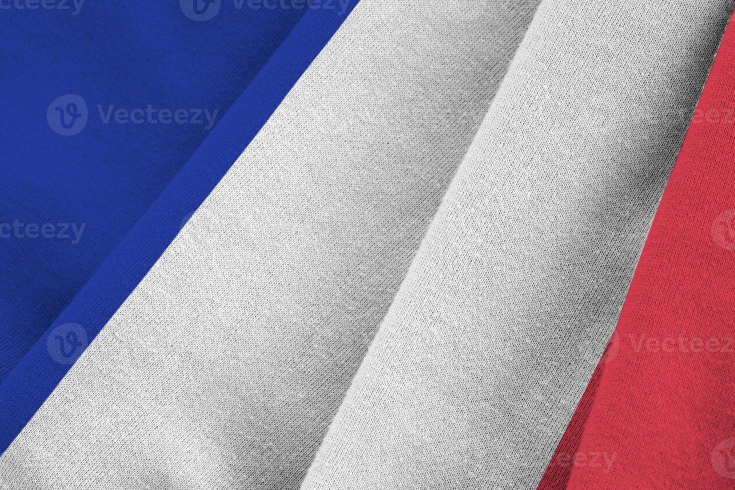 drapeau de la france avec de grands plis agitant de près sous la lumière du studio à l'intérieur. les symboles et couleurs officiels de la bannière photo