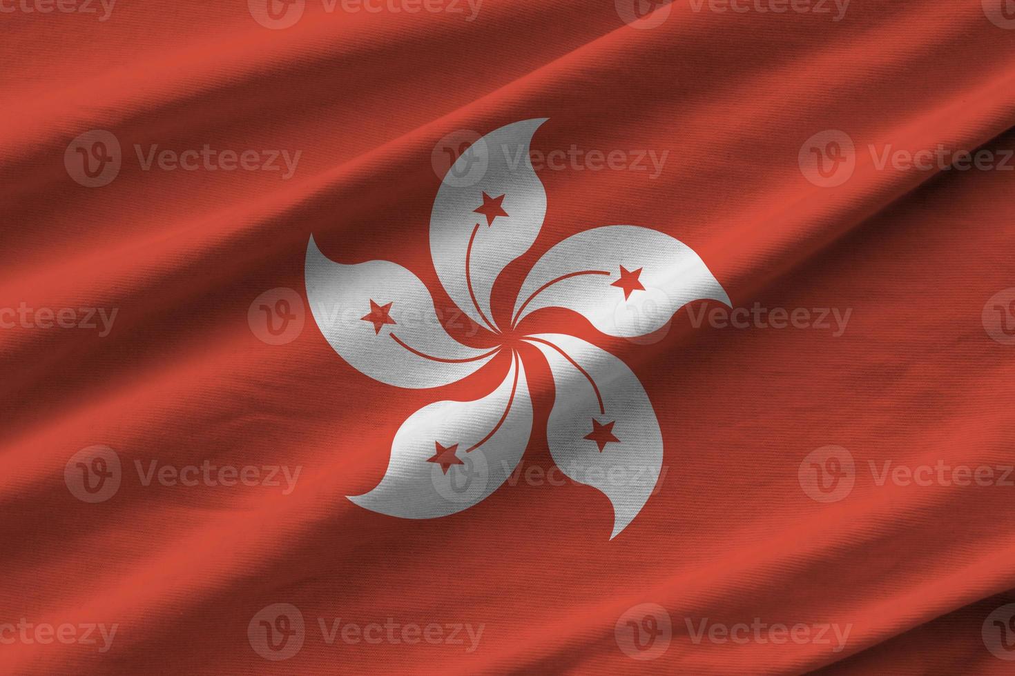 drapeau de hong kong avec de grands plis agitant de près sous la lumière du studio à l'intérieur. les symboles et couleurs officiels de la bannière photo