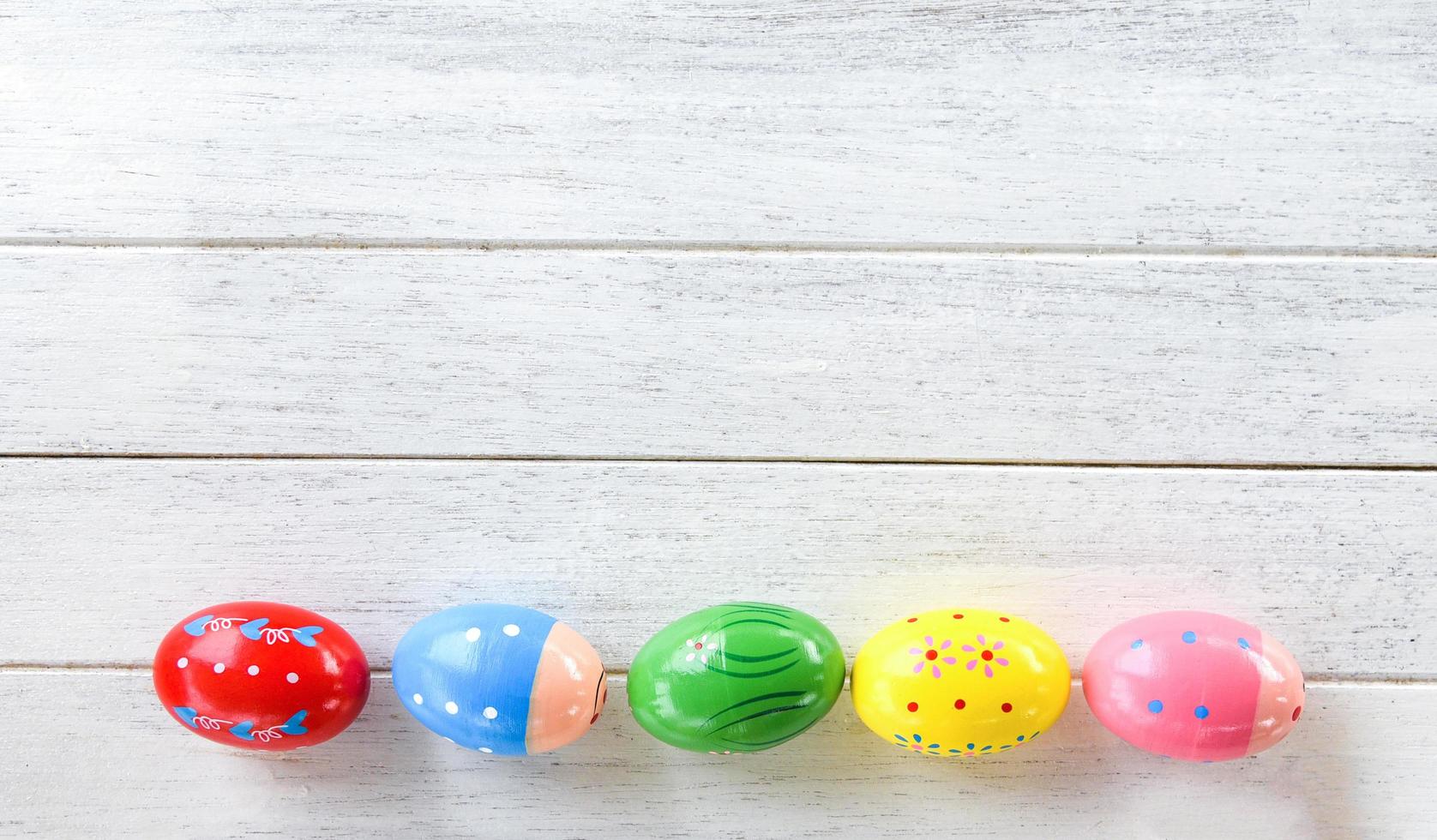 Oeufs de Pâques décoration colorée sur fond de bois blanc vue de dessus copie espace photo