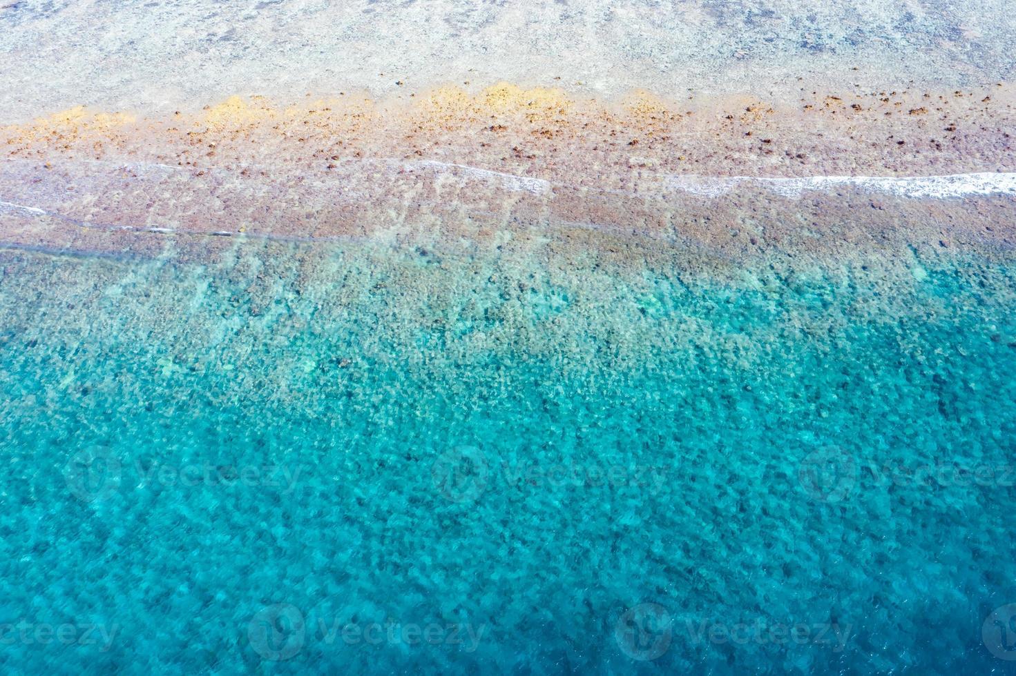 vue aérienne sur la mer, vue de dessus sur fond d'océan nature incroyable. couleurs de l'eau bleu vif, plage du lagon avec des vagues éclaboussant à la journée ensoleillée. photo de drone volant, paysage naturel incroyable avec récif de corail