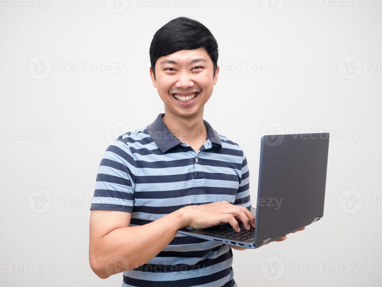 jeune homme sourire heureux à l'aide d'un ordinateur portable isolé photo