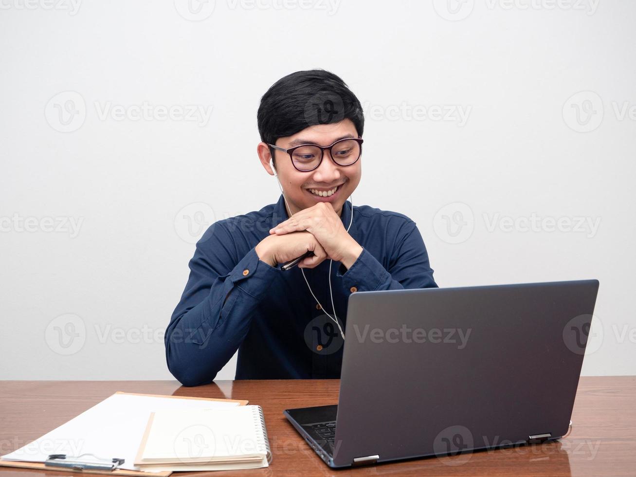 jeune homme portant des écouteurs travaillant avec un ordinateur portable sur la table, homme travaillant sur le lieu de travail photo
