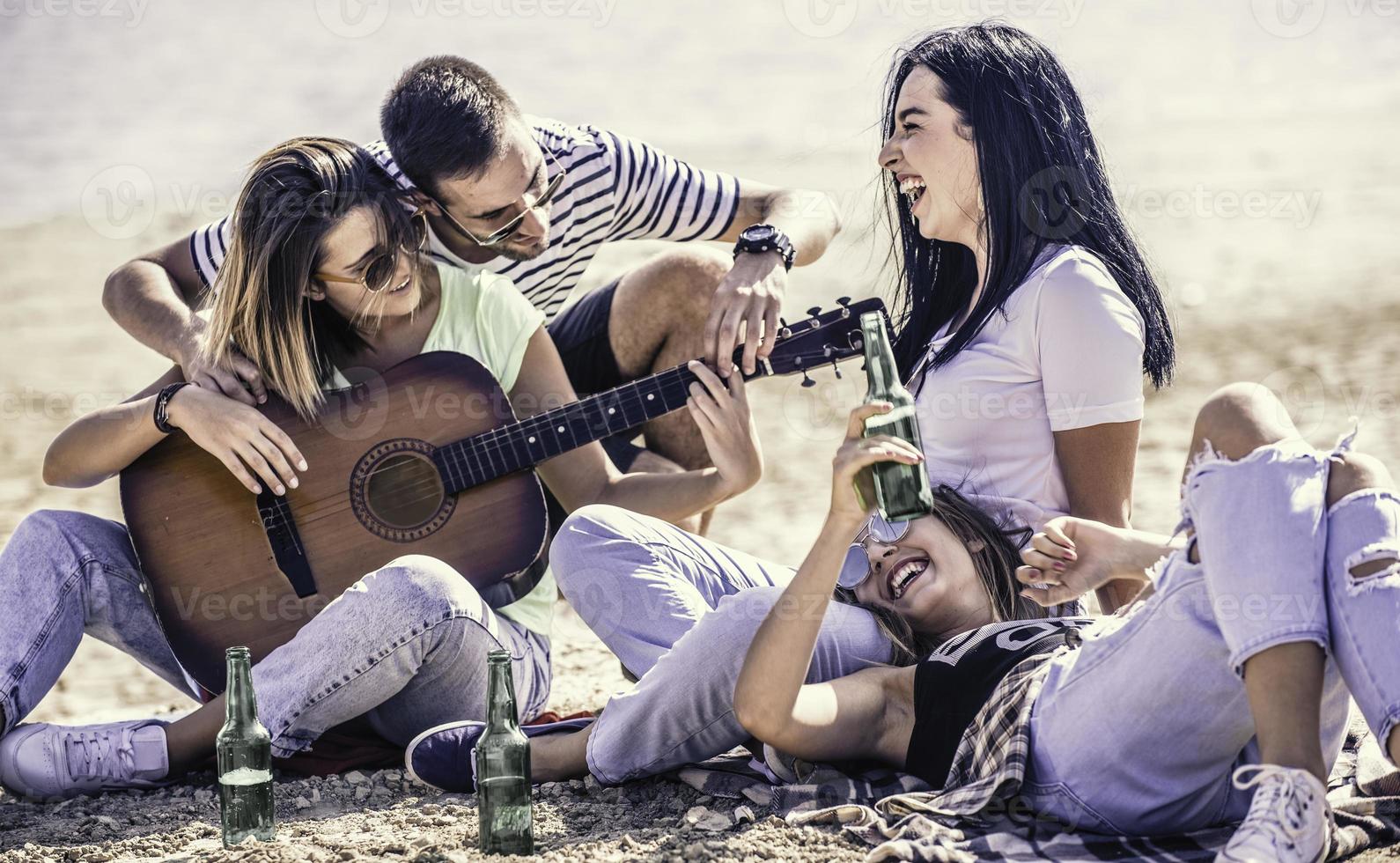 été, vacances, vacances, musique, concept de gens heureux - groupe d'amis avec guitare s'amusant sur la plage photo