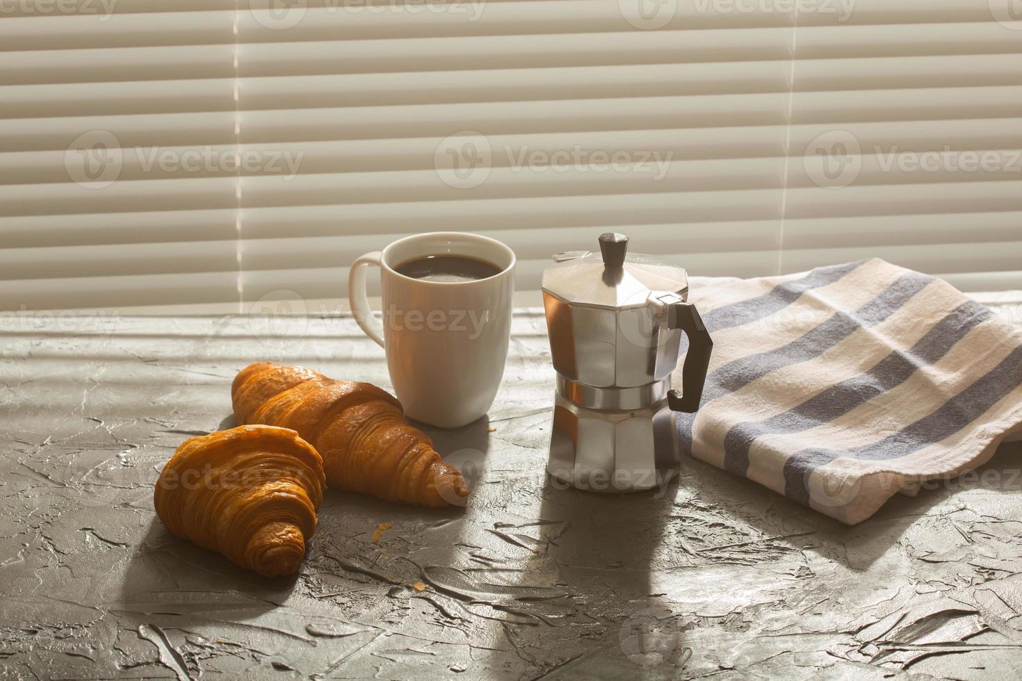 petit-déjeuner avec croissant et cafetière et moka. concept de repas du matin et de petit-déjeuner. photo