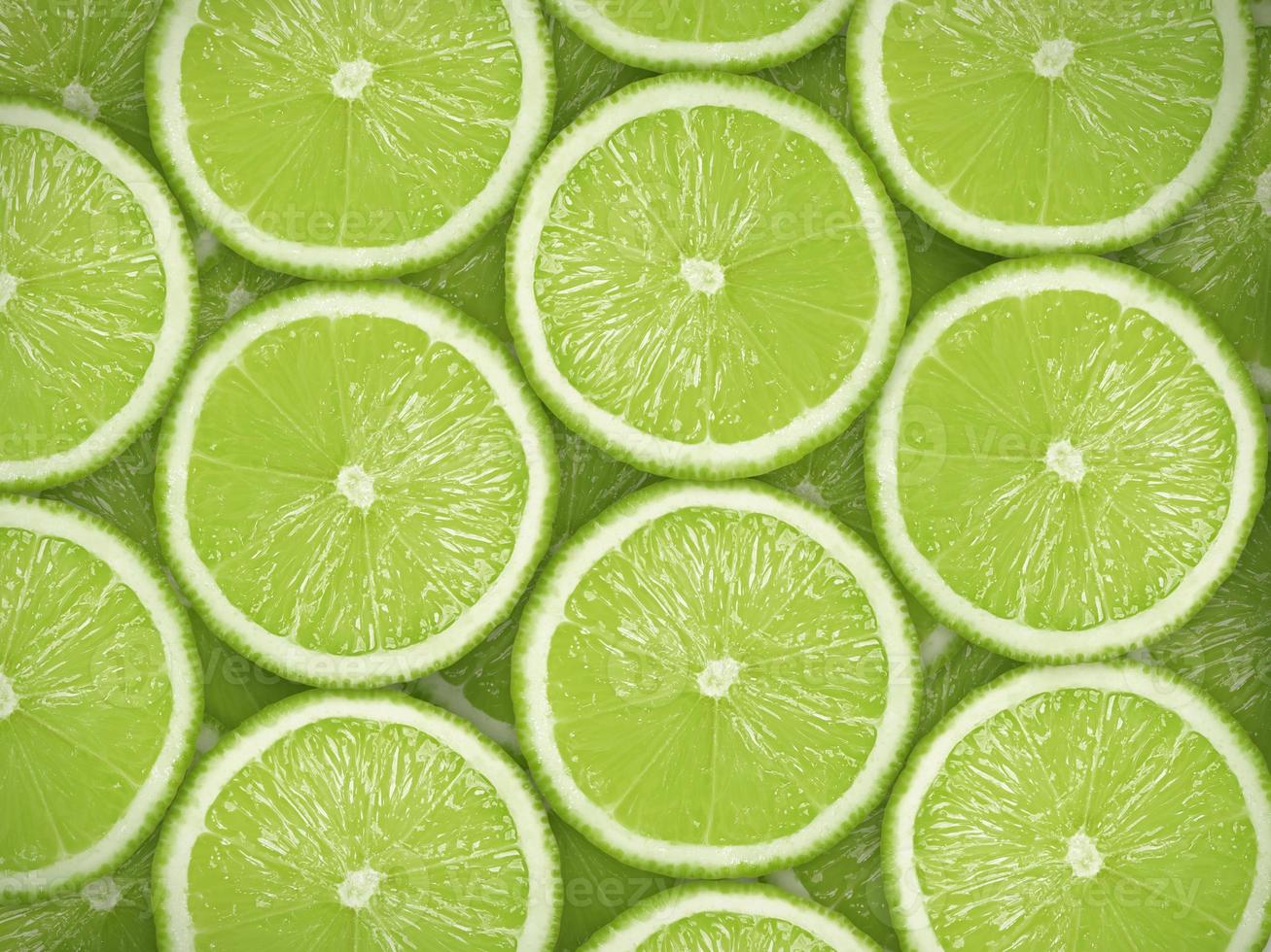 tranches de citron vert frais comme arrière-plan. photo