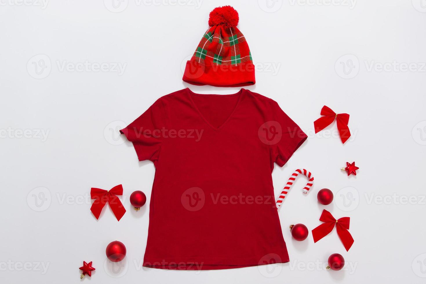 gros plan de t-shirt de modèle vierge rouge avec espace de copie. concept de vacances de noël. t-shirt maquette vue de dessus. décorations de vacances fond blanc. accessoires de bonne année. tenue de Noël. mise au point sélective photo