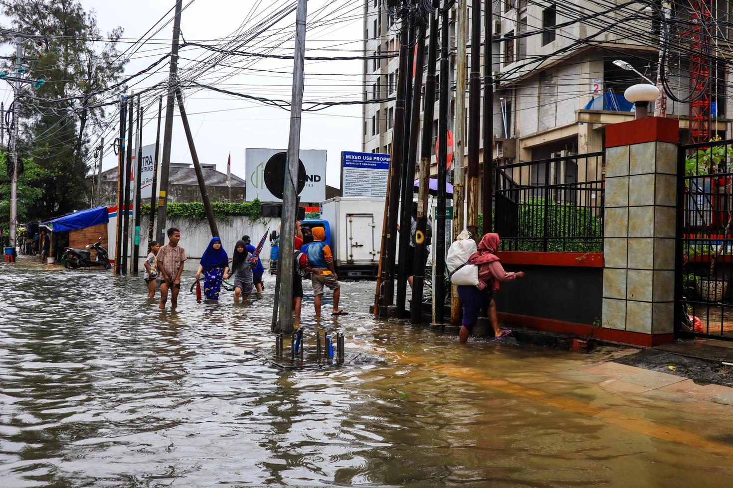 semarang, décembre 2022. plusieurs personnes transportent des sacs remplis de nourriture et de vêtements pour se préparer à l'évacuation après l'inondation de leur maison photo