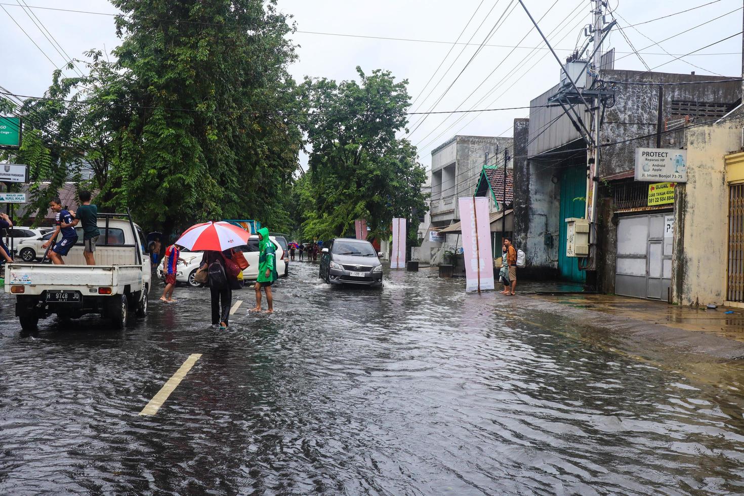 semarang, décembre 2022. certaines personnes traversent l'inondation qui a frappé le quartier de la gare de poncol et certains habitants se préparent à évacuer. conditions pendant l'inondation photo