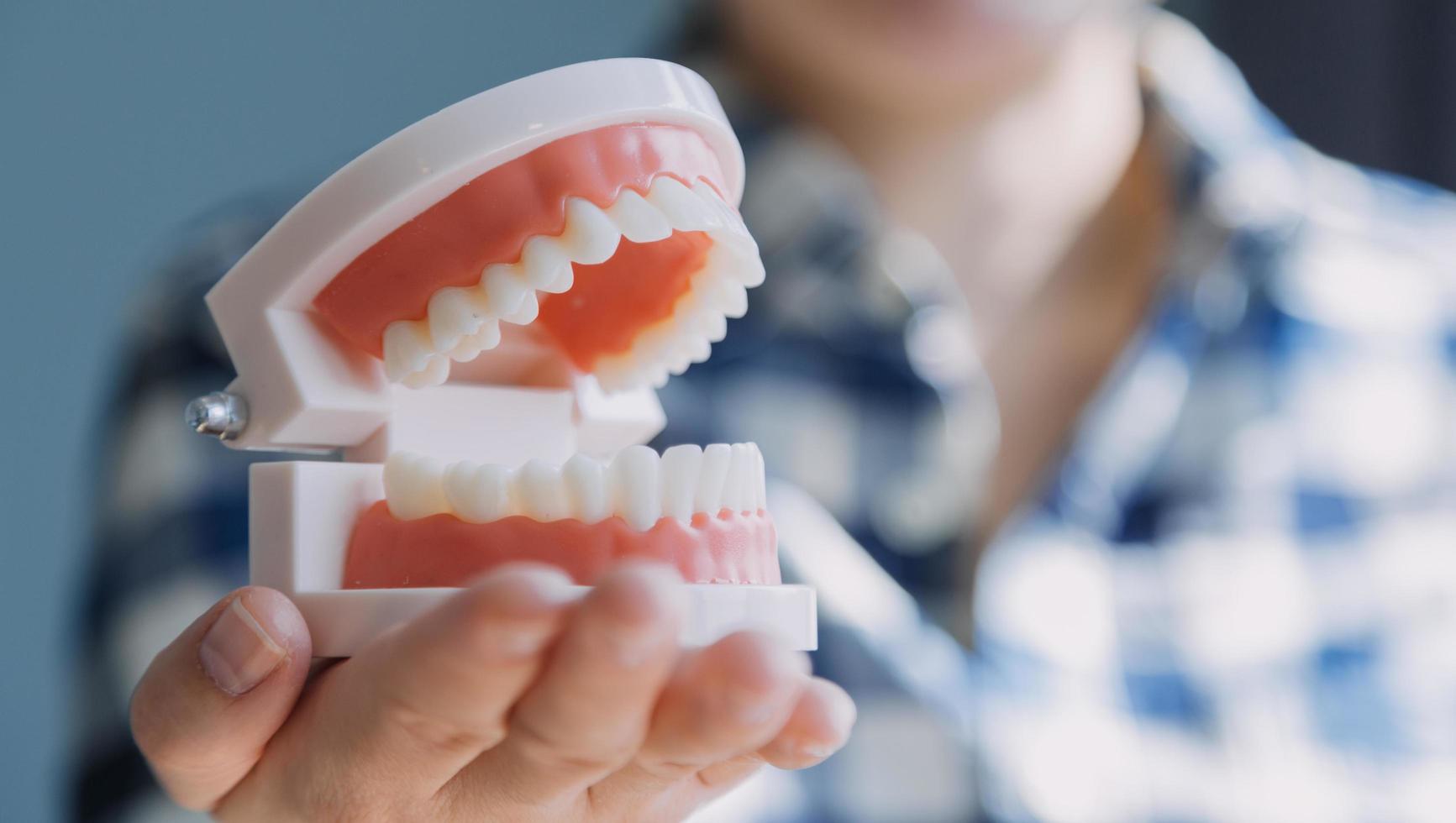 concept de stomatologie, portrait partiel d'une fille avec de fortes dents blanches regardant la caméra et souriant, les doigts près du visage. gros plan sur une jeune femme chez le dentiste, en studio, à l'intérieur photo