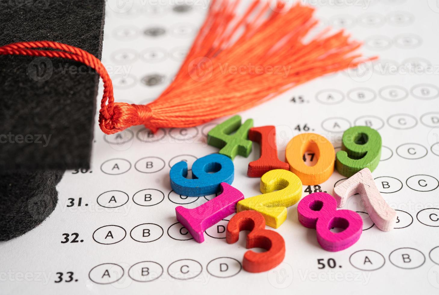 nombre mathématique coloré avec chapeau de graduation et crayon sur fond de feuille de réponses, étude de l'éducation apprentissage des mathématiques concept d'enseignement. photo