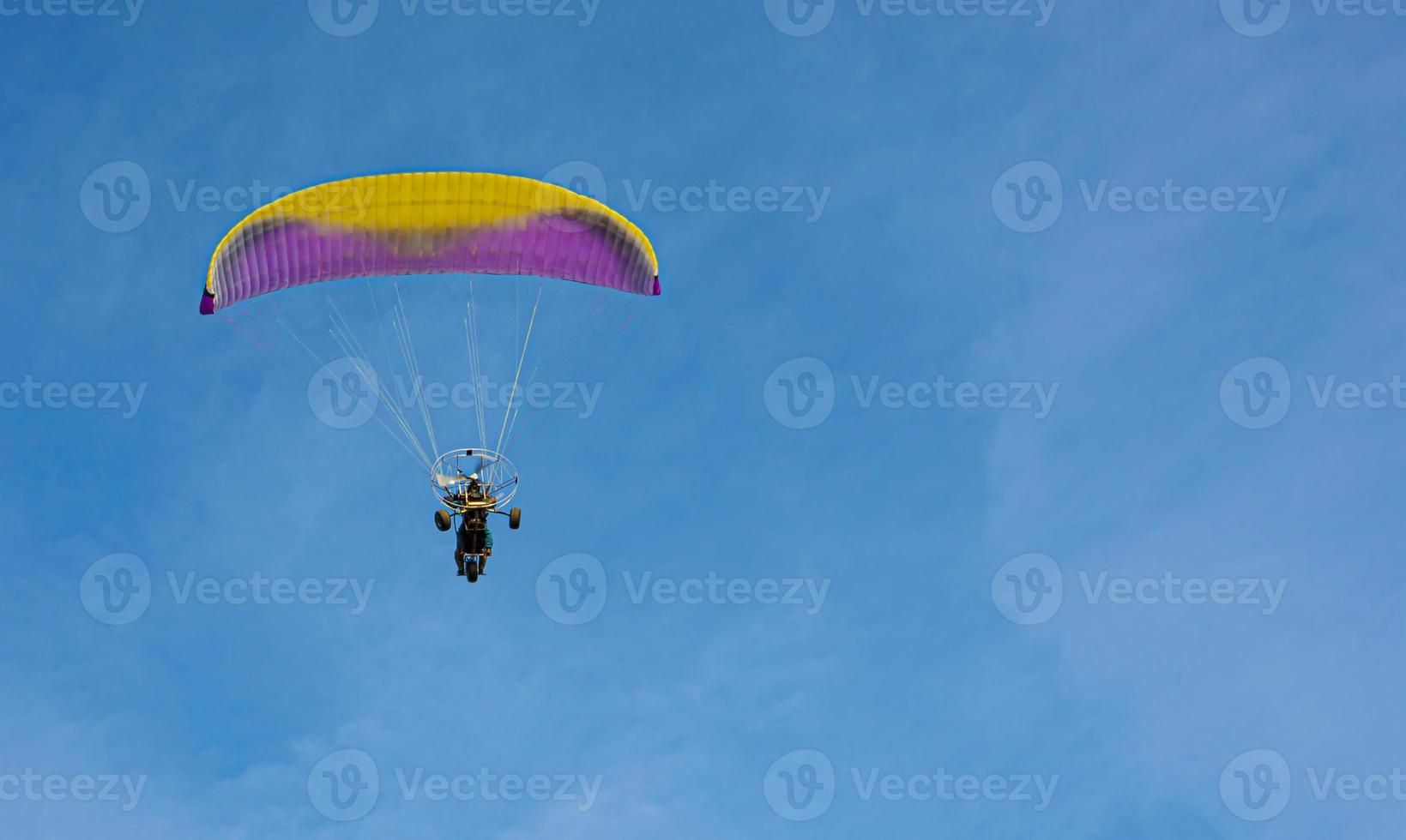 le parapente avec un moteur vole dans le ciel bleu photo