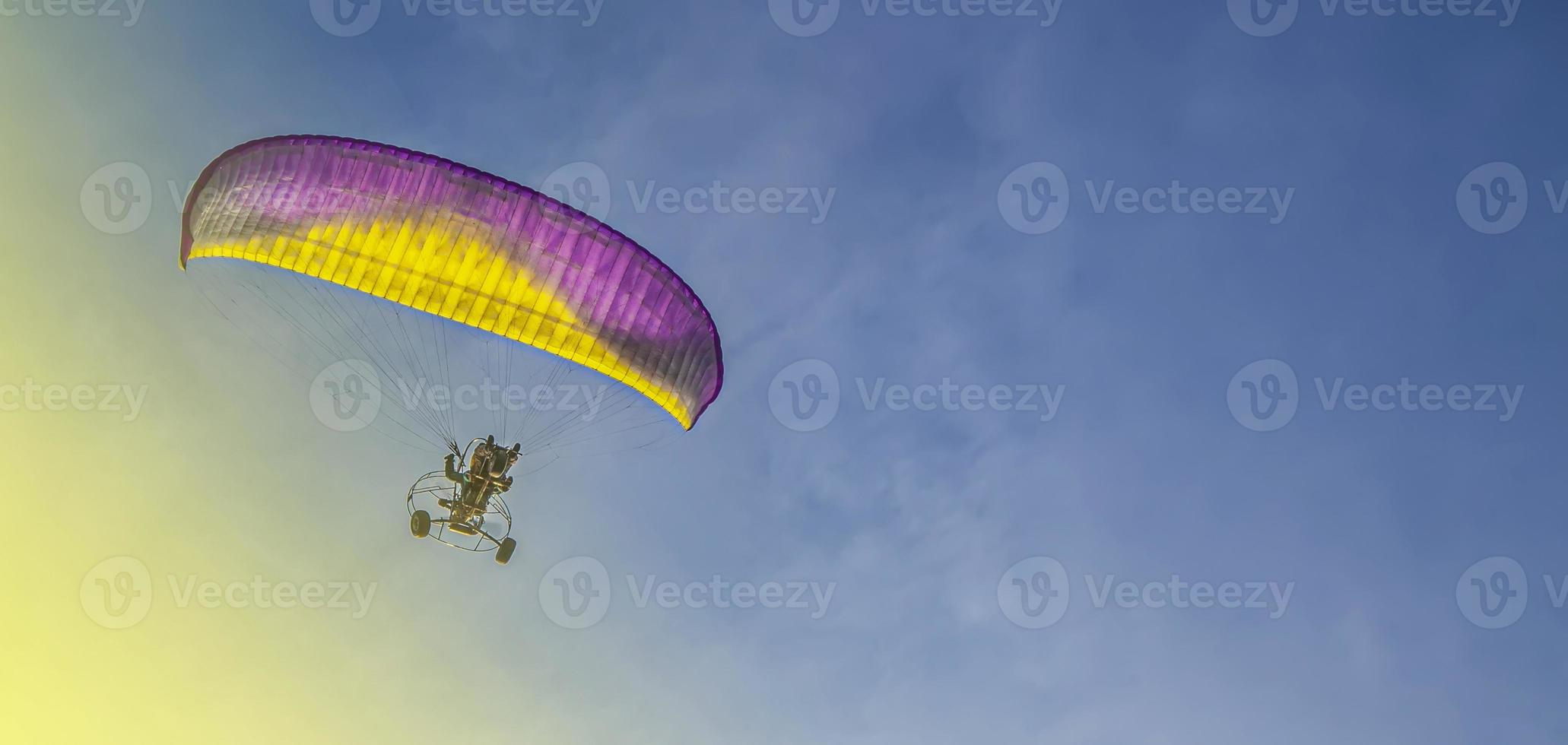 le parapente avec un moteur vole dans le ciel bleu photo