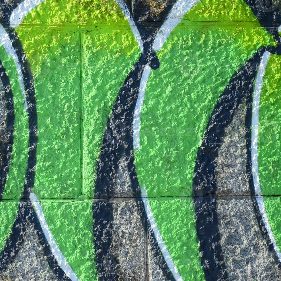 fragment de dessins de graffitis. le vieux mur décoré de taches de peinture dans le style de la culture de l'art de la rue. texture de fond colorée dans des tons verts photo