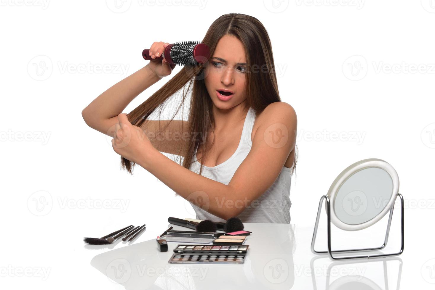 belle jeune femme regarde dans le miroir de longs cheveux bruns en bonne santé photo