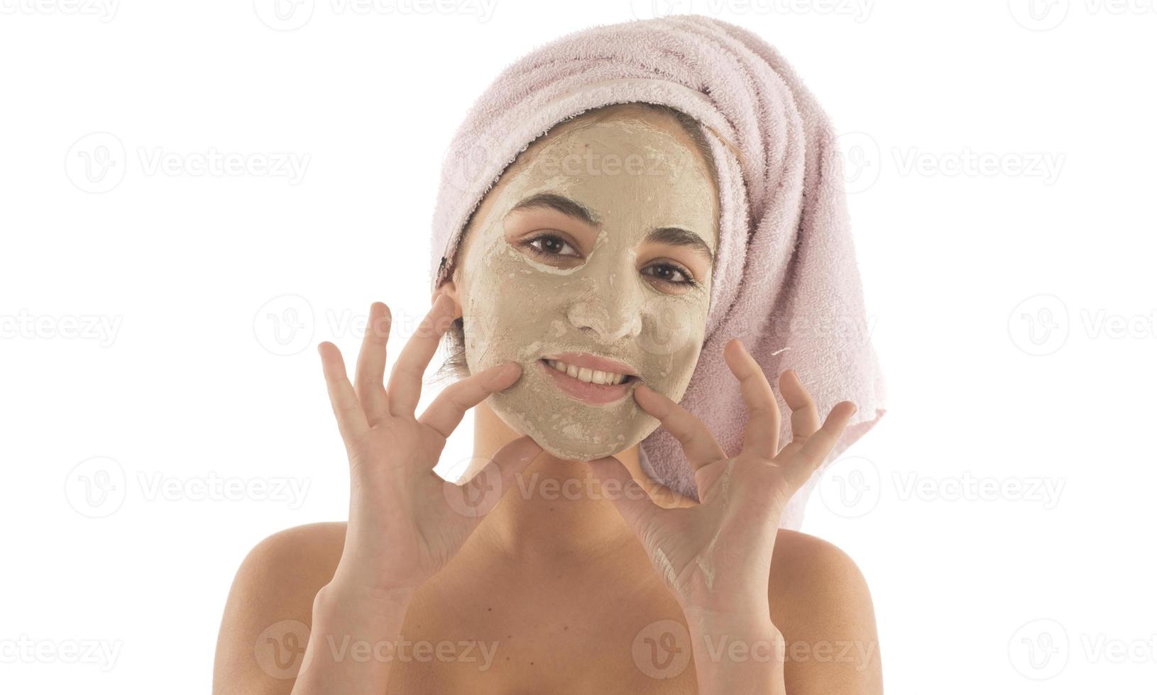 procédures de beauté concept de soins de la peau. jeune femme appliquant un masque d'argile de boue faciale sur son visage photo