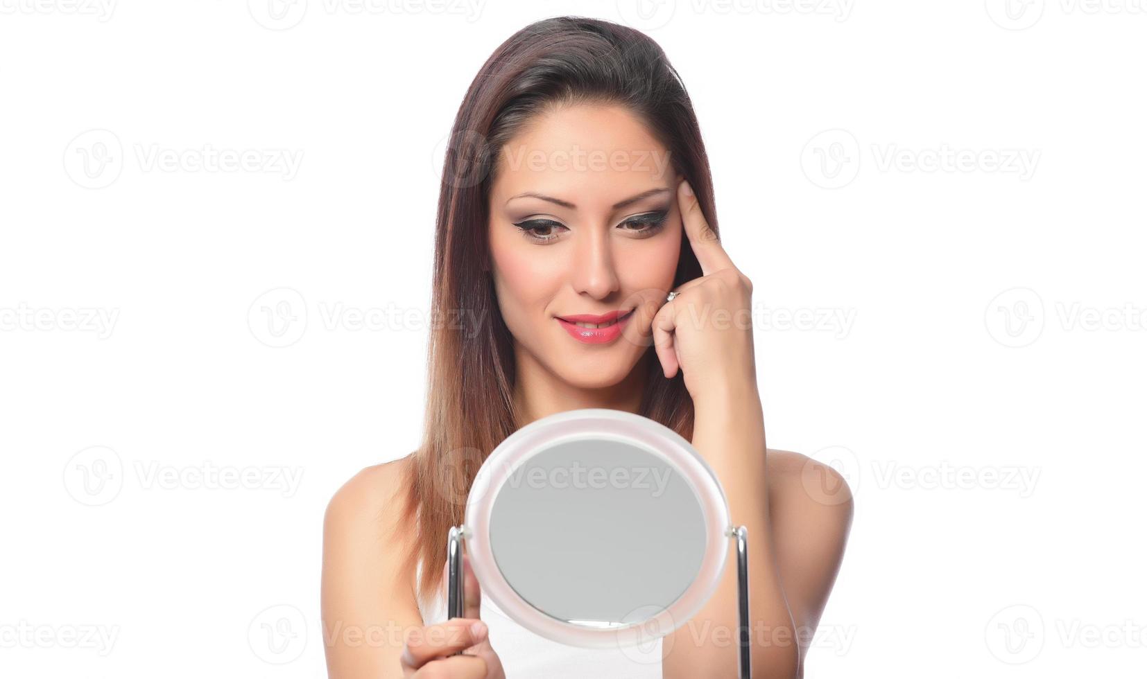 belle femme assise devant un miroir. visage d'une femme en bonne santé appliquant de la crème et du maquillage. publicité pour crème pour la peau, crème anti-rides, visage de bébé photo