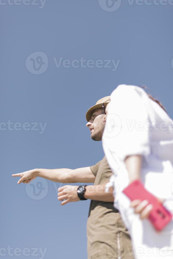 couple d'amoureux reposant sur la jetée, homme pointant vers le lac photo