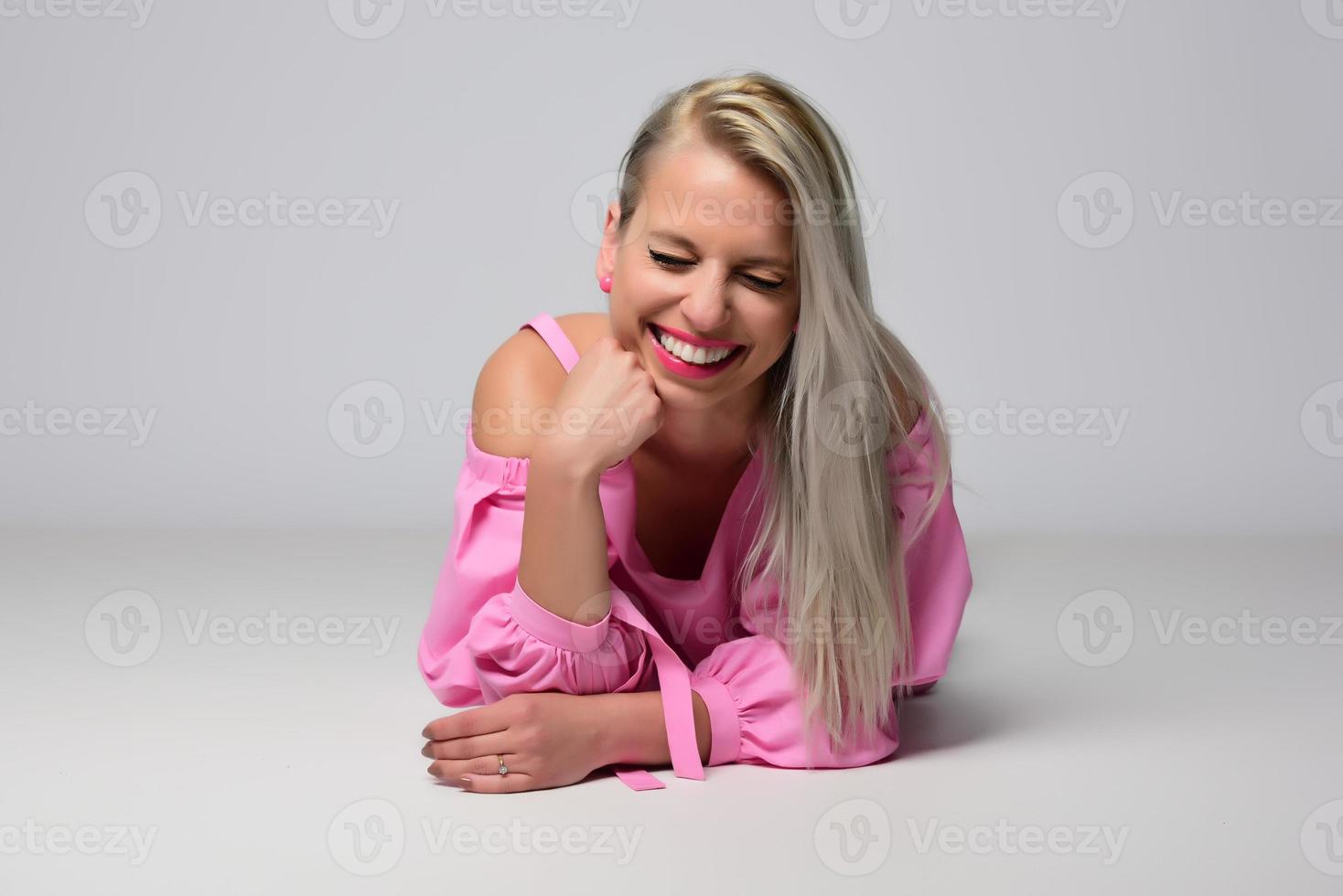 femme souriante à la mode blonde portant des accessoires modernes posant en studio photo