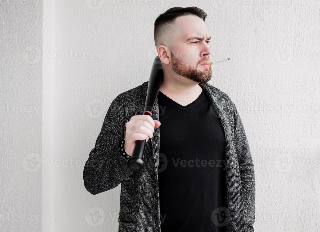 homme barbu brutal fume une cigarette. photo