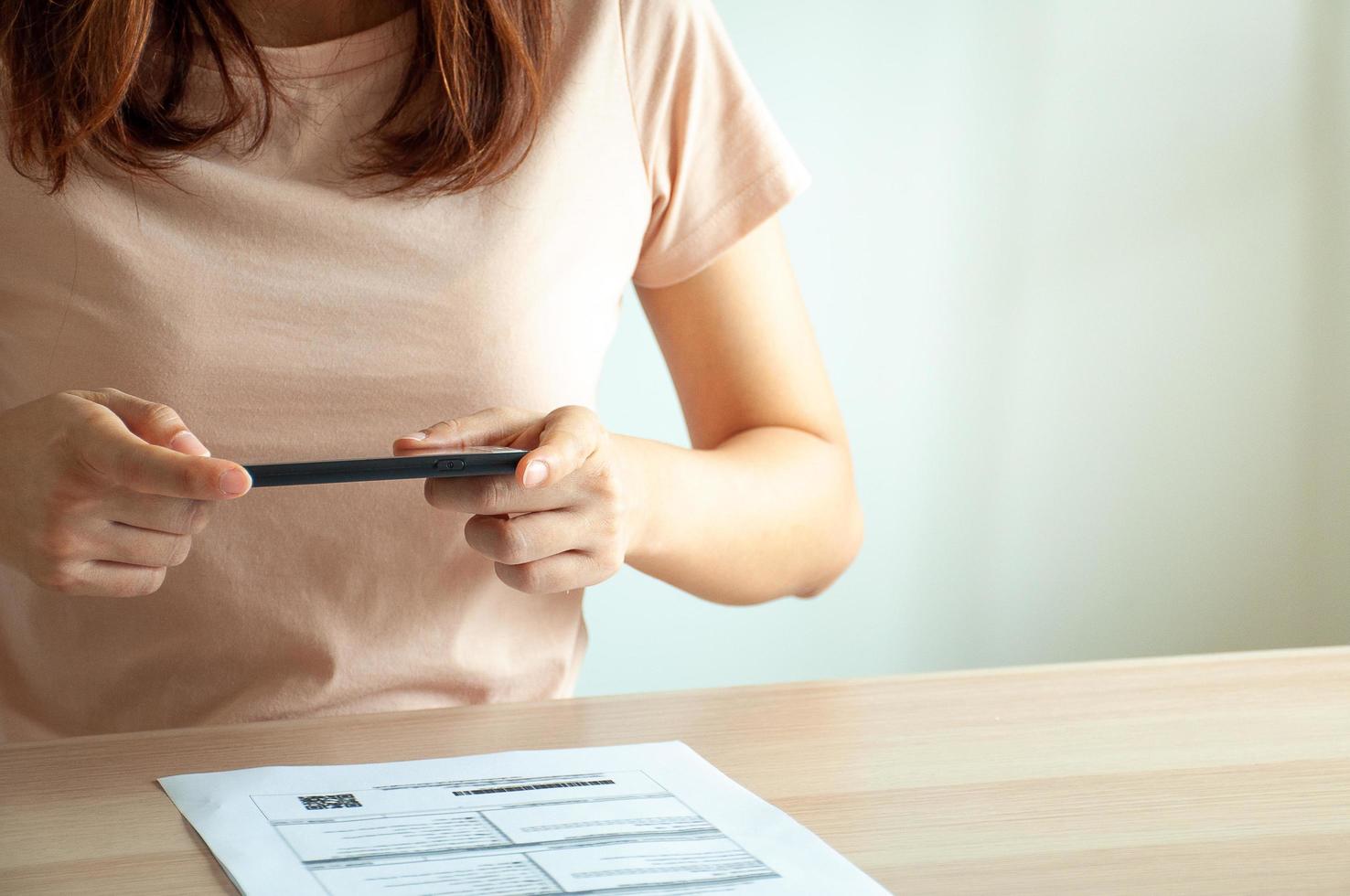 la femme de ménage utilise le téléphone pour scanner le code qr. l'entraîneur paie la facture. la technologie moderne permet d'effectuer facilement et rapidement diverses transactions financières via des applications. photo