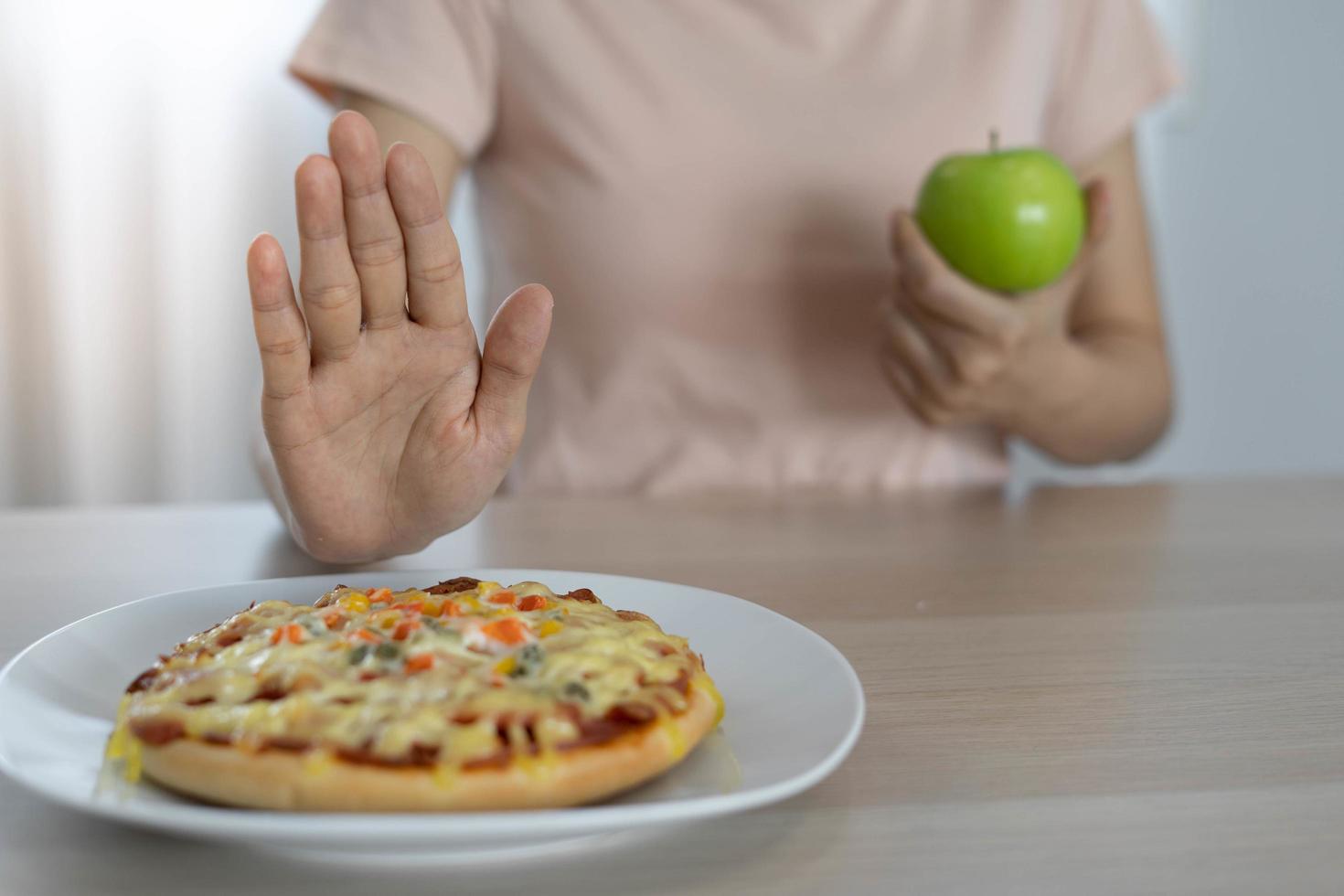 les femmes au corps mince choisissent pendant les aliments sains et la malbouffe, les femmes choisissent la pomme verte pour l'alimentation. bonne nourriture saine. perte de poids, équilibre, contrôle, réduction des graisses, faibles calories, routines, exercice. photo