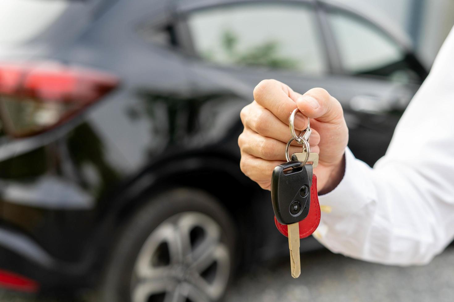 louer, louer une voiture, vendre, acheter. le directeur de la concession envoie les clés de la voiture au nouveau propriétaire. vente, pret credit financier, location vehicule, assurance, location, vendeur, concessionnaire, mensualite, entreprise d'entretien automobile photo