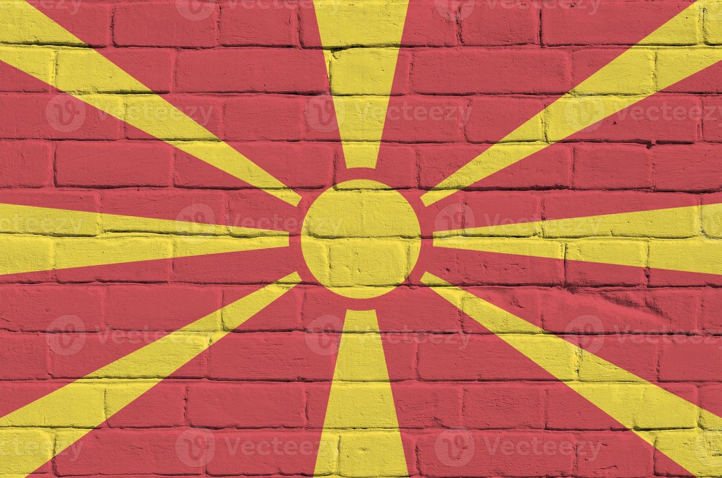 drapeau macédoine représenté dans des couleurs de peinture sur un vieux mur de briques. bannière texturée sur fond de maçonnerie de gros mur de briques photo