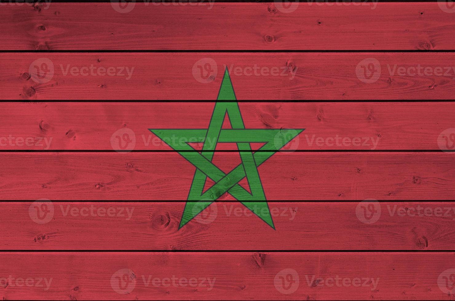 drapeau marocain représenté dans des couleurs de peinture vives sur un vieux mur en bois. bannière texturée sur fond rugueux photo