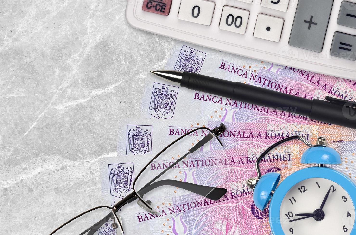 50000 billets de leu roumains et calculatrice avec lunettes et stylo. prêt commercial ou concept de saison de paiement des impôts. le temps de payer les impôts photo