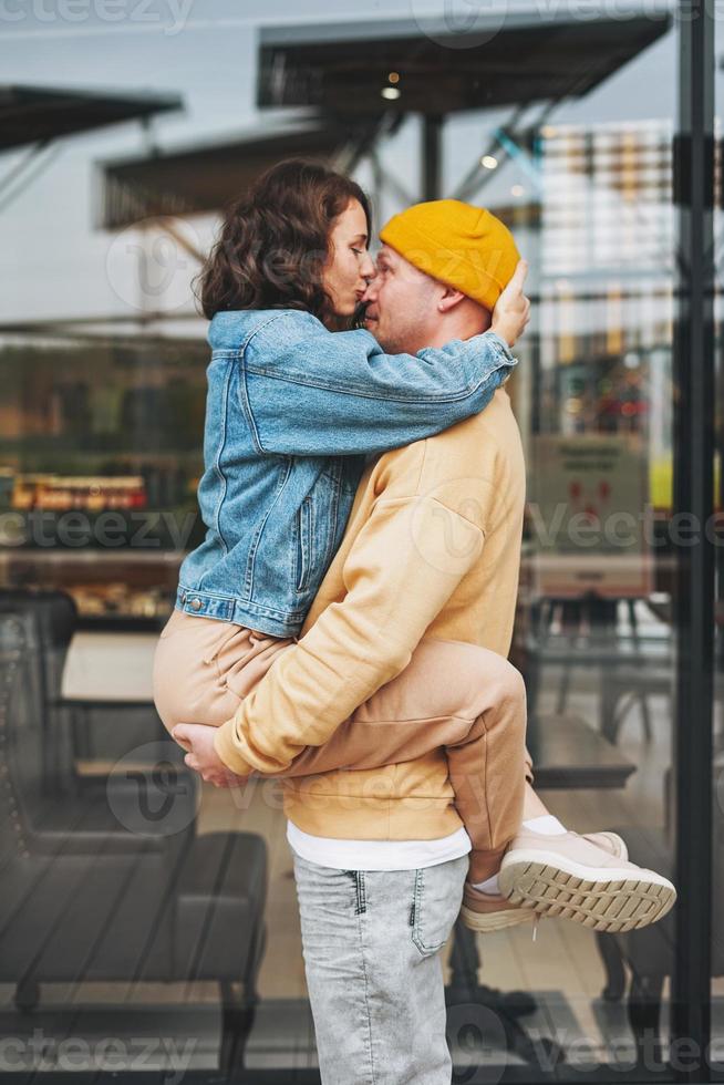 heureux élégant jeune couple de famille amoureux hipsters s'amusant contre le mur de verre photo