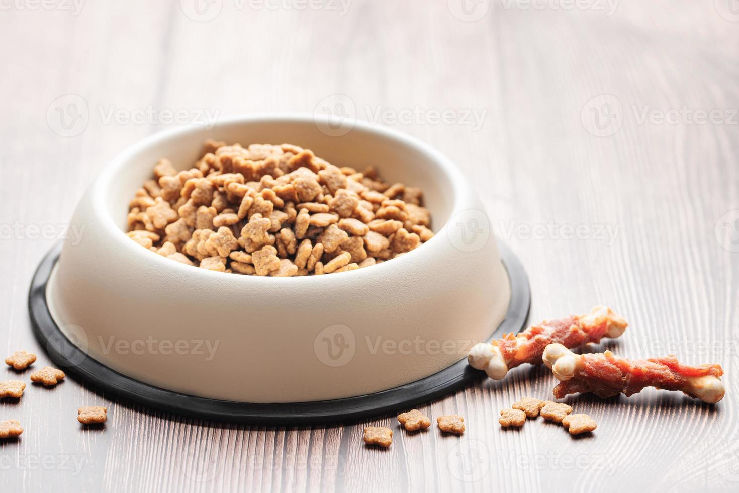 un bol de nourriture pour chien sur un plancher en bois. photo