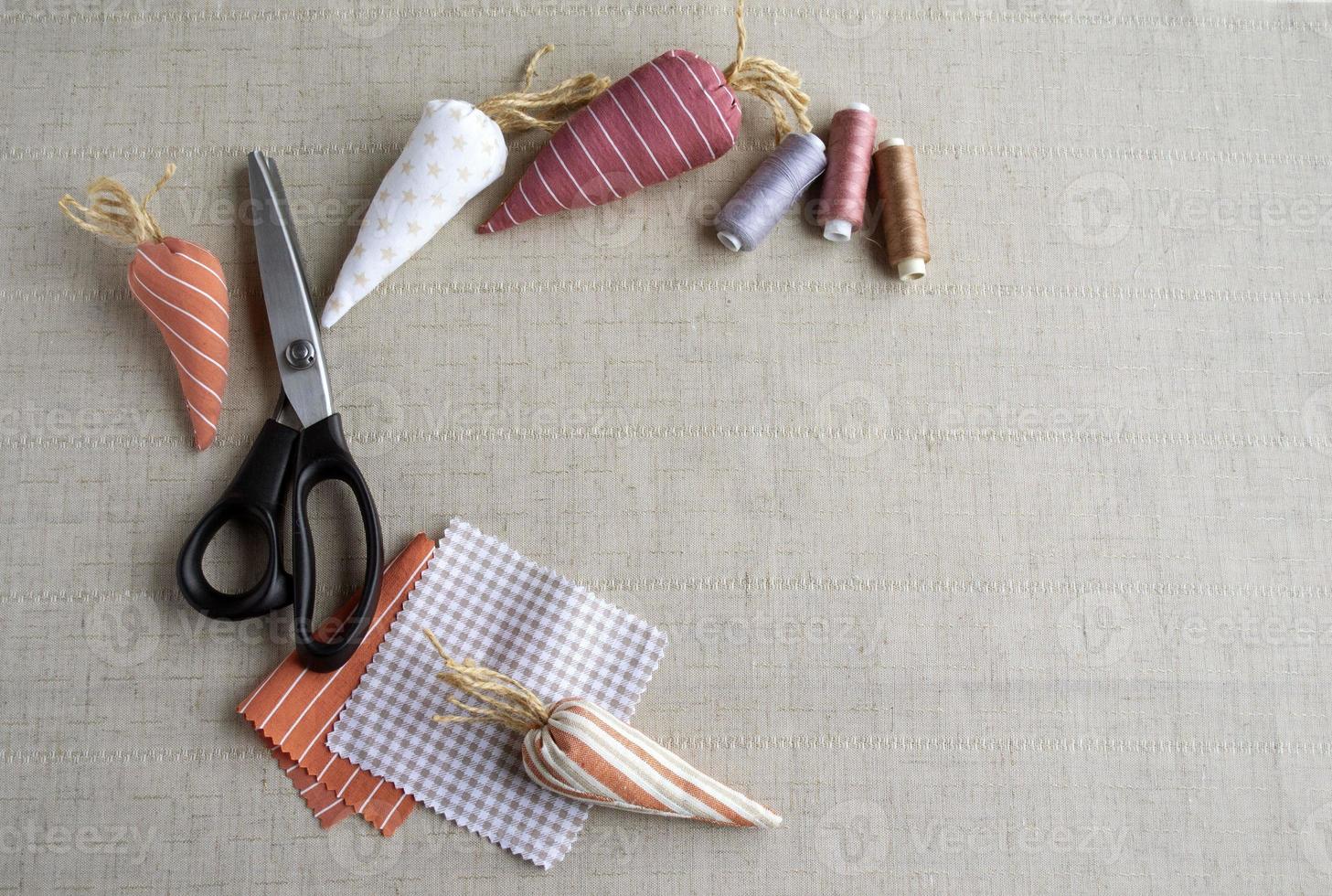 couture de pâques, outils de couture, fil, ciseaux, carottes en tissu, décor pour décorer la maison pour pâques. espace pour le texte. photo