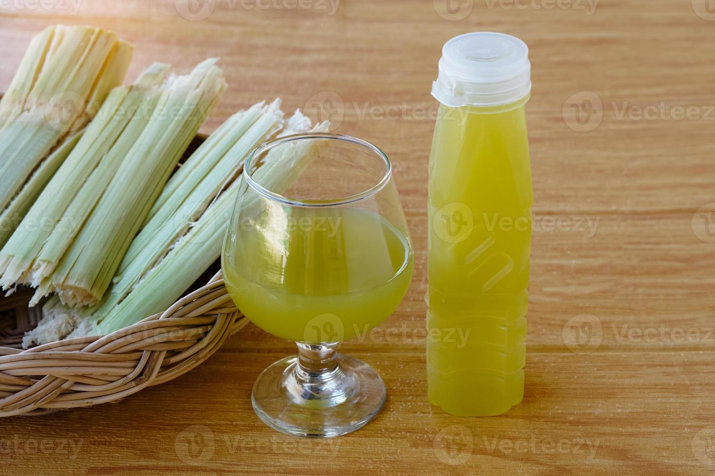 bouteilles de jus de canne à sucre frais. et bagasse après avoir pressé pour boire un verre dans un panier. concept, boisson naturelle saine à base de cultures agricoles. boissons maison, a des propriétés médicinales et à base de plantes photo