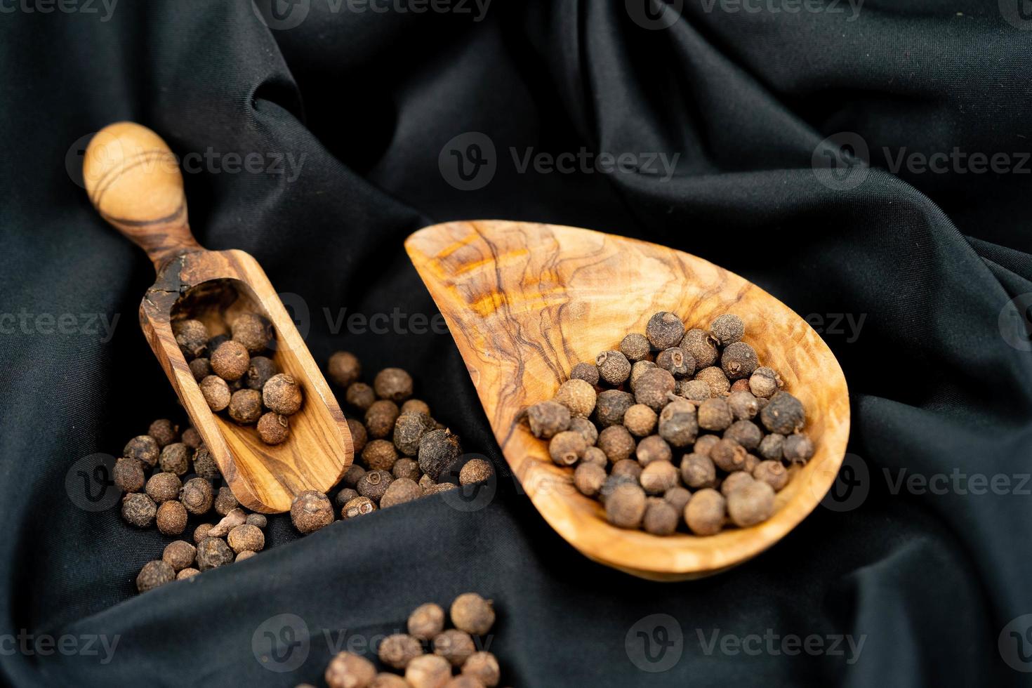 piment quelques boules de piment de la Jamaïque sur bois d'olivier photo