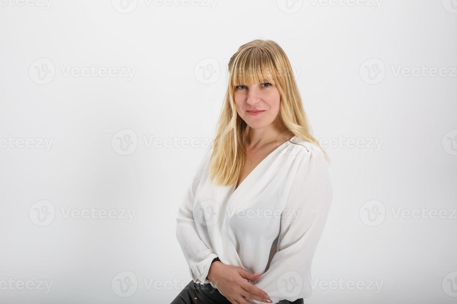 portrait en gros plan d'une fille blonde modèle en pull en laine blanche sur fond blanc en studio photo