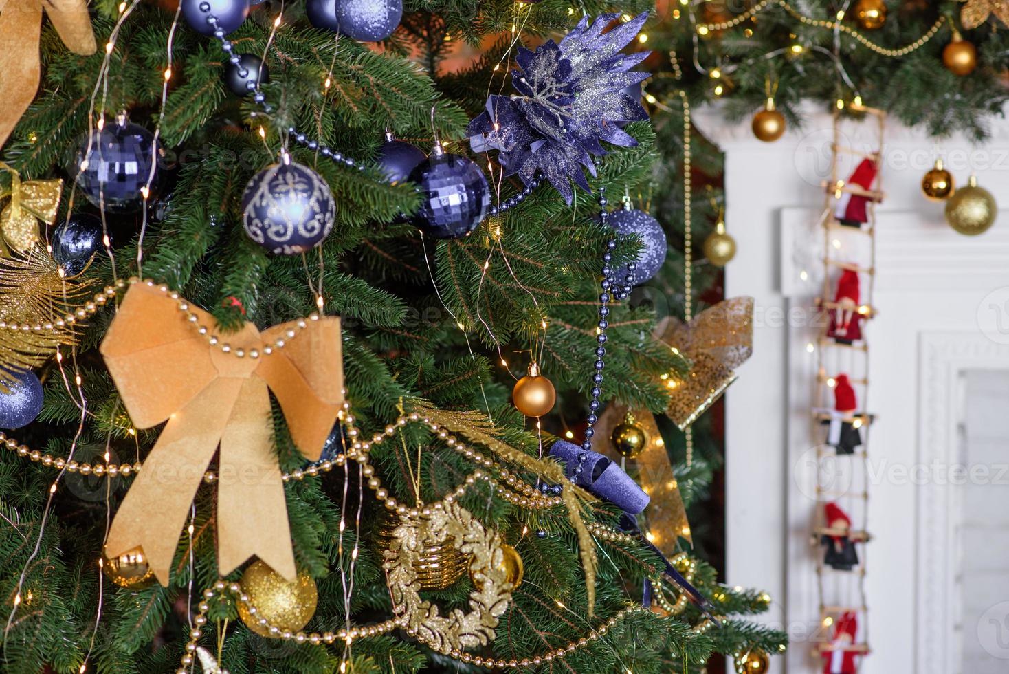 beau sapin de noël avec guirlandes, boules et jouets photo