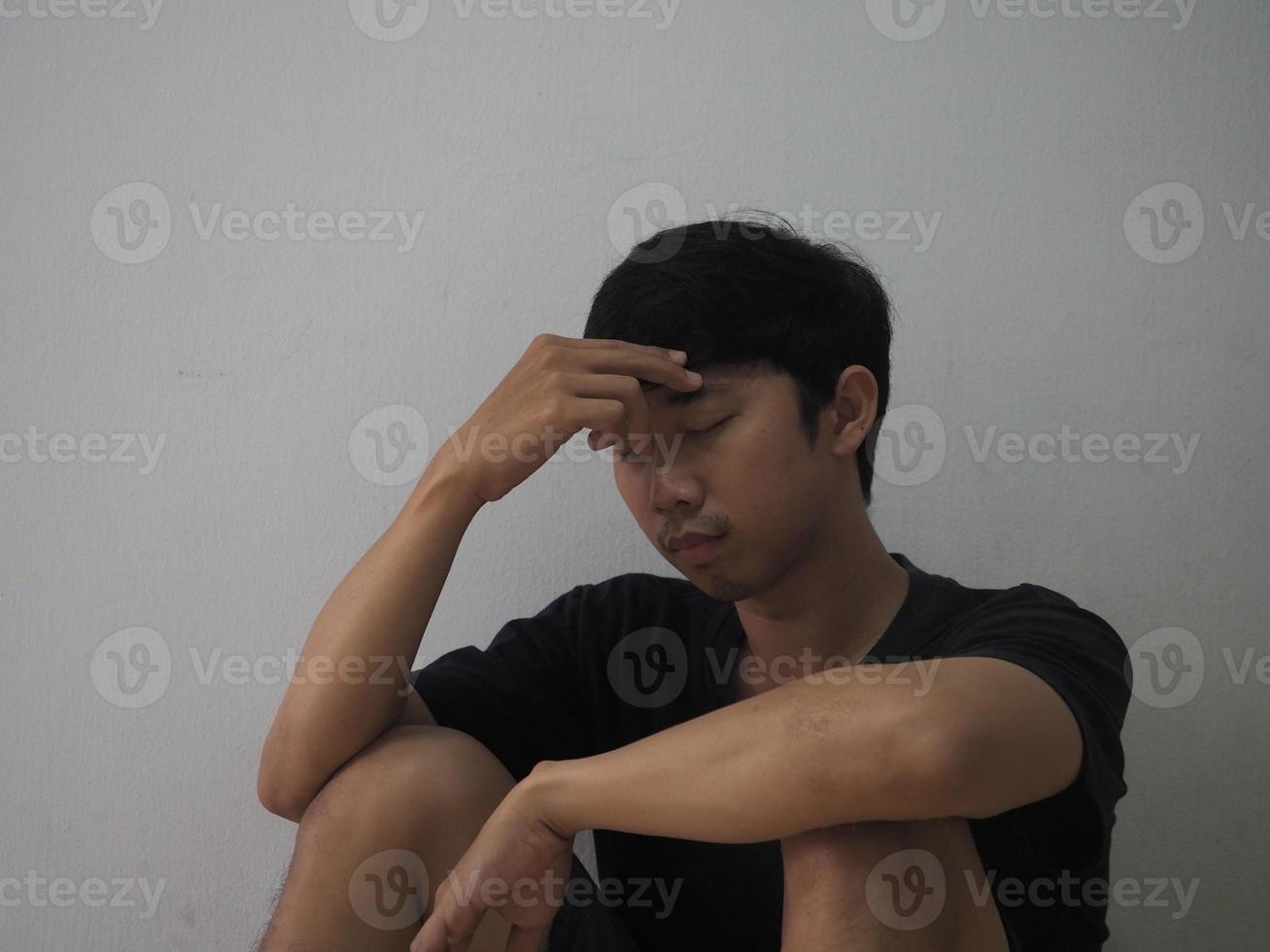 un homme asiatique ferme son visage se sent désespéré et déprimé photo