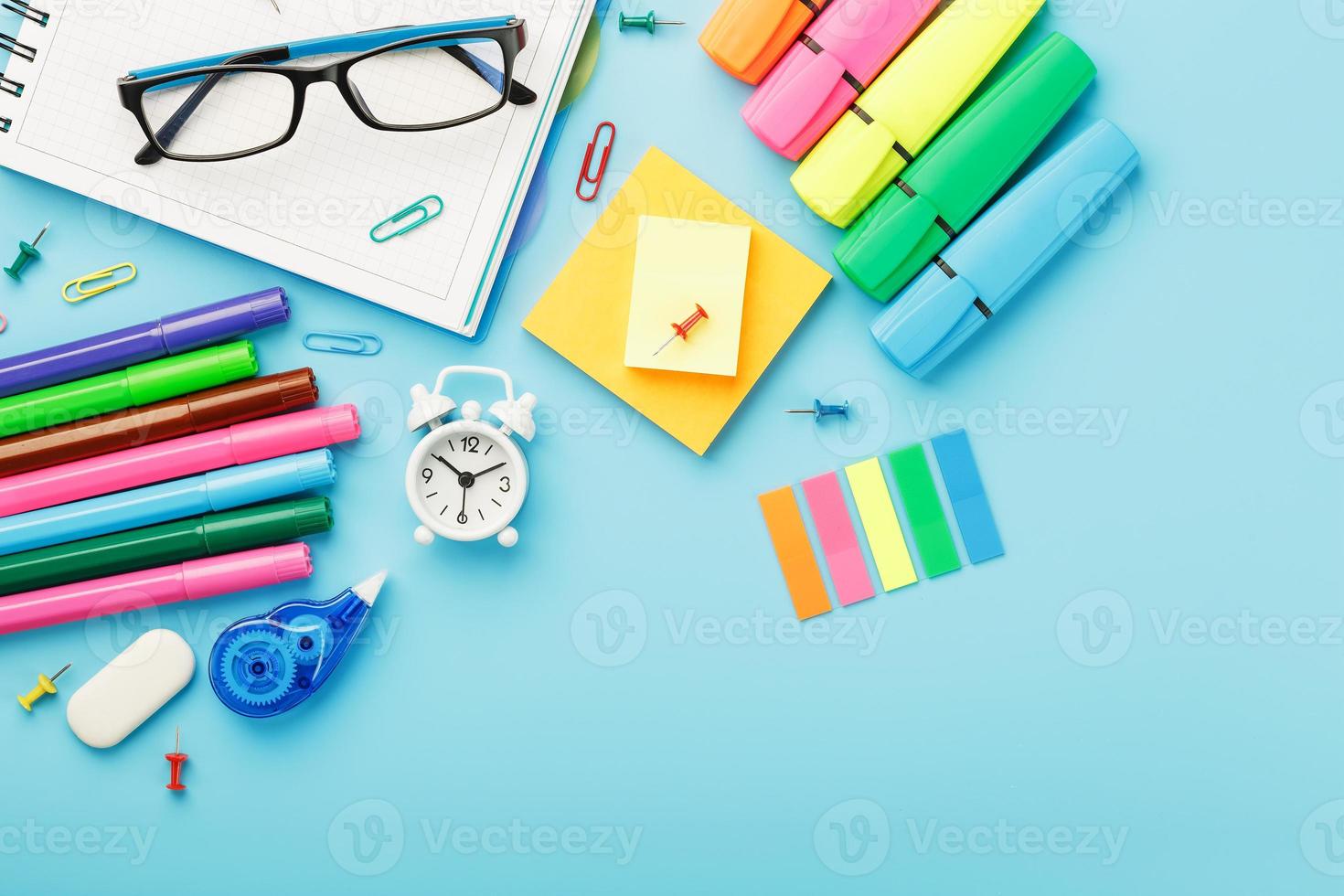 les fournitures de bureau se trouvent sur un fond bleu. étudier à l'école. couleur arc-en-ciel. photo