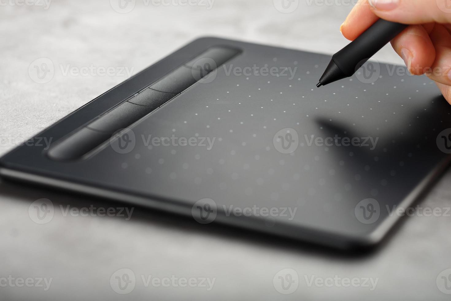 stylo avec une tablette graphique entre les mains du designer, gros plan. gadget pour l'art et le travail. photo