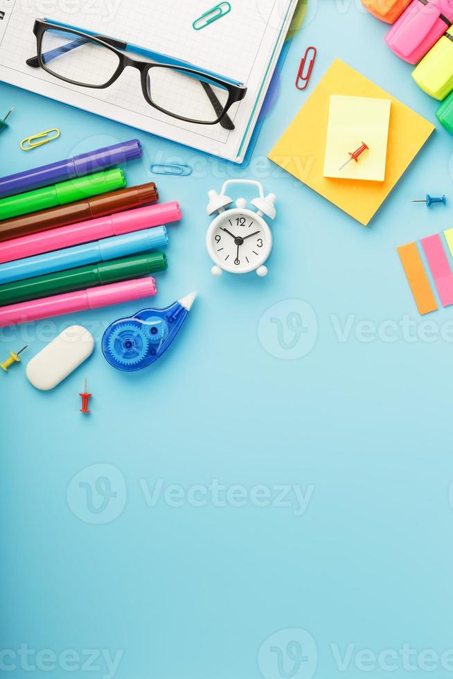 les fournitures de bureau se trouvent sur un fond bleu. étudier à l'école. couleur arc-en-ciel. photo