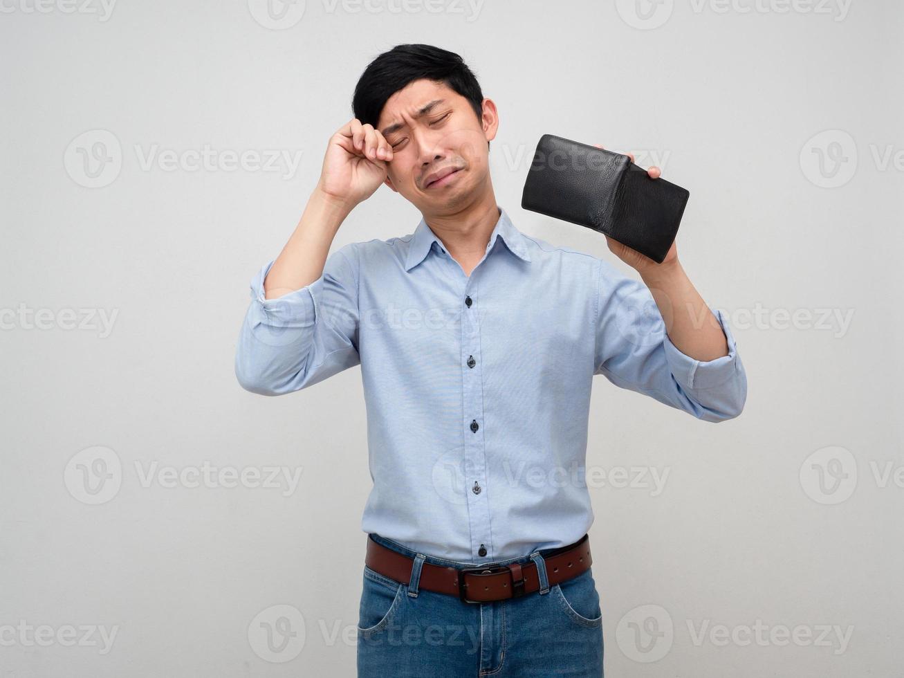 homme d'affaires asiatique se sent découragé et pleure à propos de pas d'argent, le pauvre homme tient son portefeuille sans argent photo