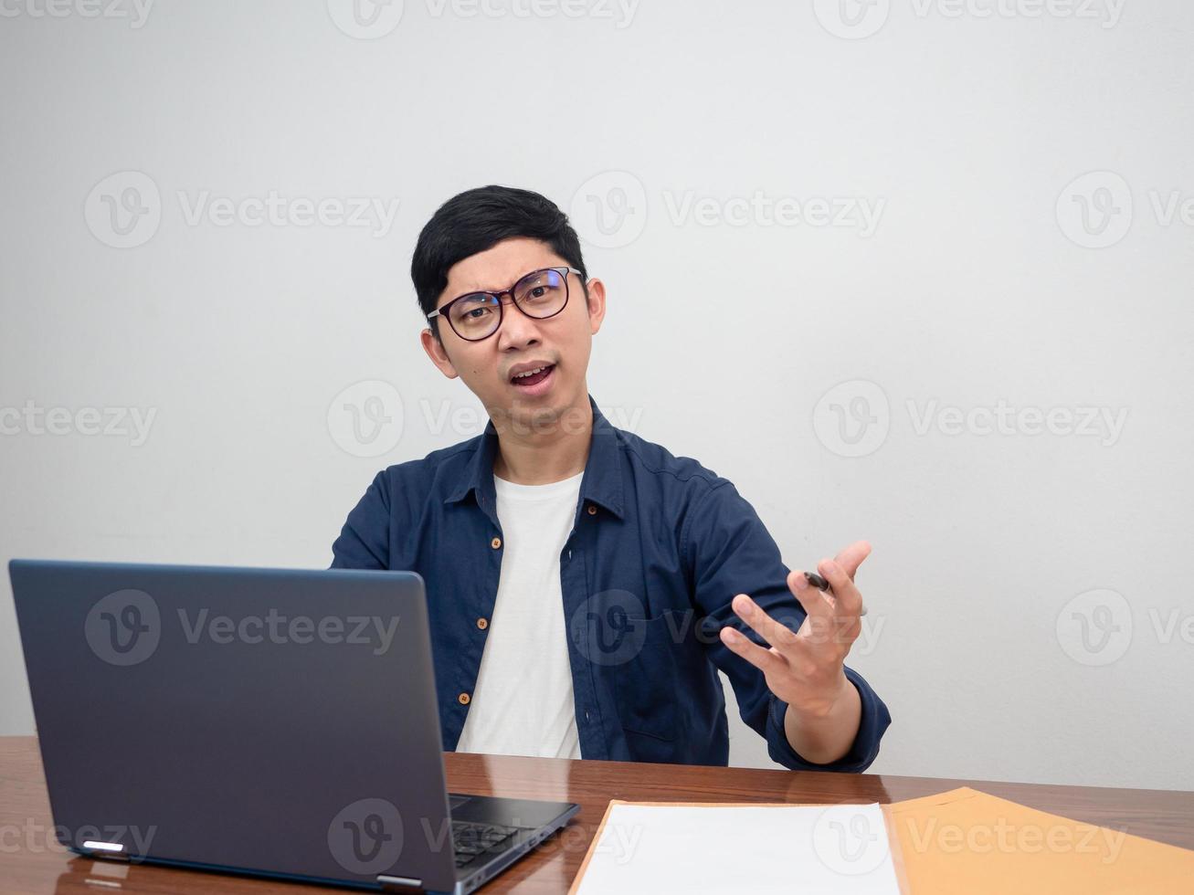 un homme d'affaires porte des lunettes s'assoit à une table de travail se sent en colère à propos de travailler dur photo