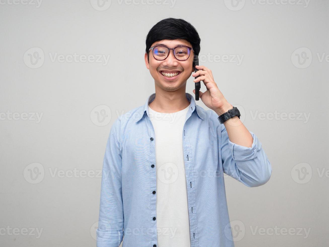 homme positif porter des lunettes parler téléphone portable sourire heureux isolé photo